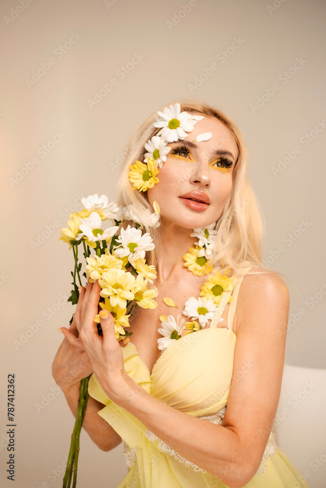 Portrait of a pretty girl with a bouquet of chrysanthemums. White and yellow flowers and petals on the face. Beauty concept Portrait of a pretty girl with a bouquet of chrysanthemums. White and yellow flowers and petals on the face. Beauty concept