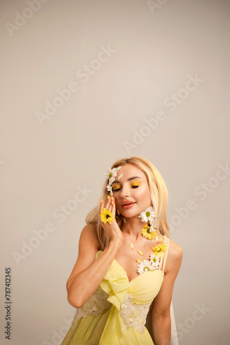 Beautiful woman with flowers and petals on her face. Beauty concept. White and yellow chrysanthemums
