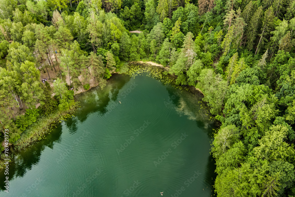 Aerial view of beautiful Balsys lake, one of six Green Lakes, located in Verkiai Regional Park. Birds eye view of scenic emerald lake surrounded by pine forests. Vilnius, Lithuania. Aerial view of beautiful Balsys lake, one of six Green Lakes, located in Verkiai Regional Park. Birds eye view of scenic emerald lake surrounded by pine forests. Vilnius, Lithuania.