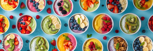 Top view of colorful fruit bowls neatly arranged, offering a variety of healthy, fresh options on a bright background.