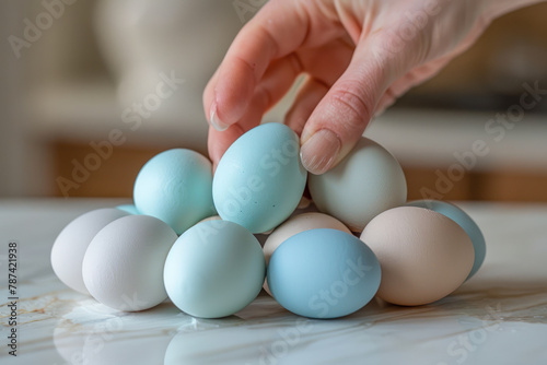 A hand grabbed a duck egg from a pile on the table