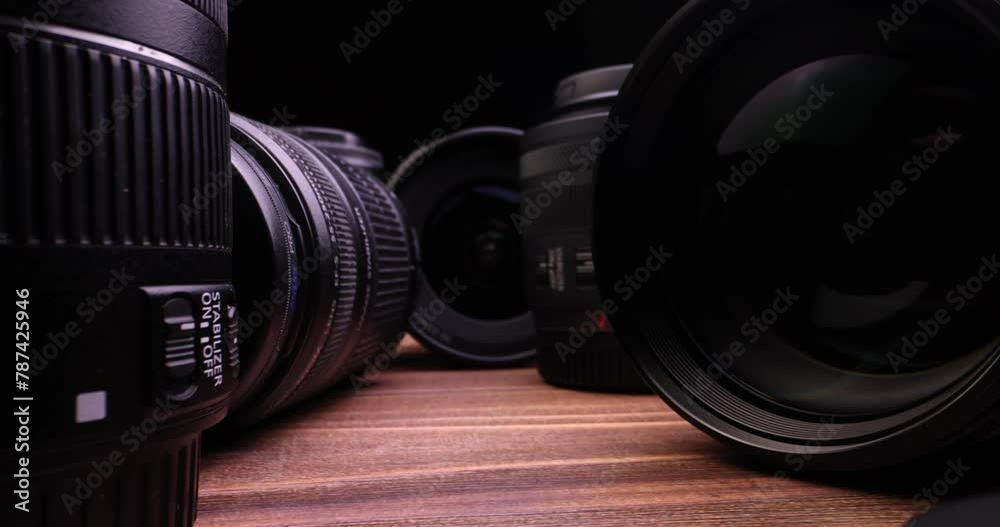 Very close-up of photo camera and video camera lense isolated on a black background in slow motion.