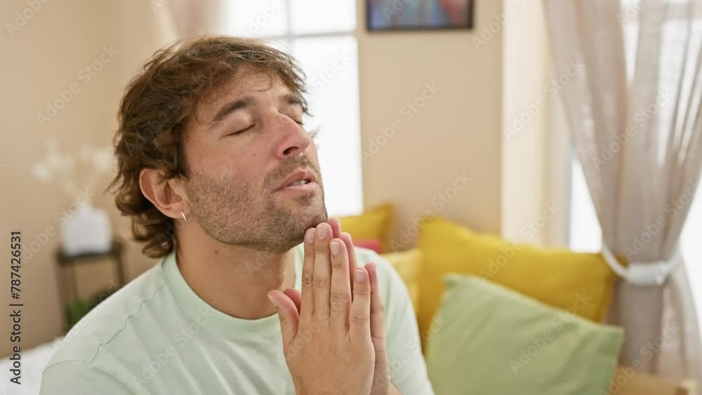 Smiling young caucasian man in pyjamas confidently praying for forgiveness in the peaceful sanctum of his bedroom. Smiling young caucasian man in pyjamas confidently praying for forgiveness in the peaceful sanctum of his bedroom.
