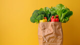 A bag of vegetables is displayed on a yellow background. The vegetables include broccoli, tomatoes, and peppers.