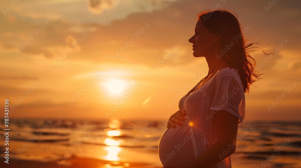 Portrait of a young pregnant woman at sunset by the sea.