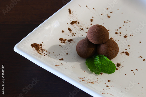 Traditional Brazilian Chocolate Cacao Brigadeiro Balls With Mint On White Plate