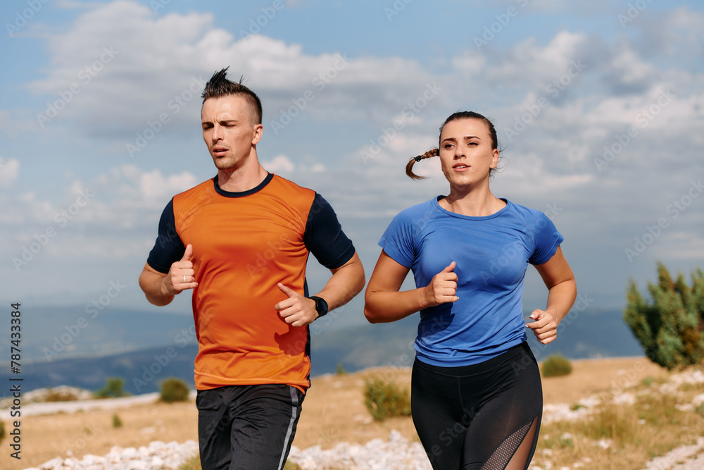 A couple dressed in sportswear runs along a scenic road during an early morning workout, enjoying the fresh air and maintaining a healthy lifestyle A couple dressed in sportswear runs along a scenic road during an early morning workout, enjoying the fresh air and maintaining a healthy lifestyle