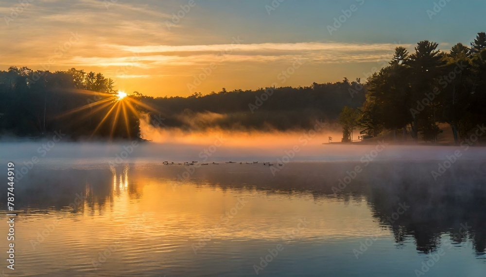 A serene sunrise over a mist-covered lake