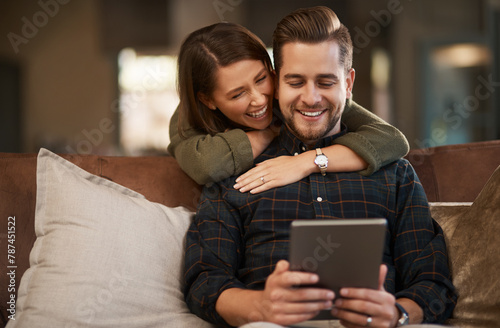 Home, hug and couple with tablet, love and search for restaurant or social media post with romance in lounge. Apartment, embrace or woman with man on couch and tech with online reading or digital app