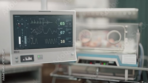 Tracking health condition of young patient on life support at a hospital. Modern technology supports the life of a sick newborn patient. Life support monitor detects rapid decline in patients pulse. photo