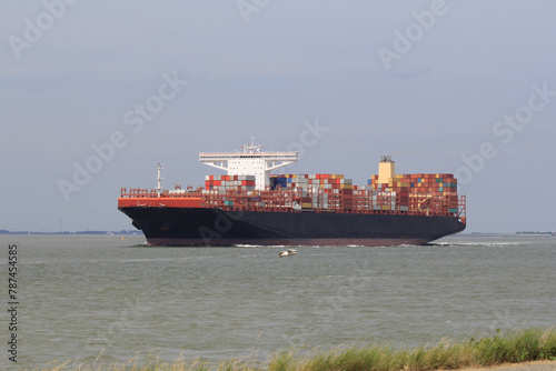 a big container ship sails in the sea closeup