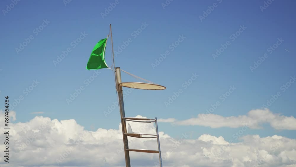 A green flag waving on the lifeguard tower. Safe swimming at the beach. 4K A green flag waving on the lifeguard tower. Safe swimming at the beach. 4K