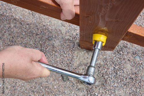Ratchet socket wrench is used to tighten bolt when assembling outdoor furniture. photo