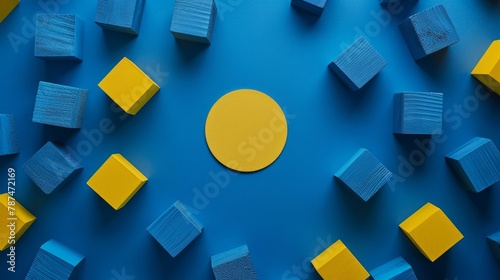 A simple and vibrant composition featuring blue toy cubes and a yellow circle arranged on a dark blue backdrop © Chingiz