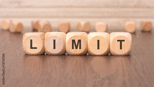 the text 'limit' is written on wooden cubes on a brown background photo