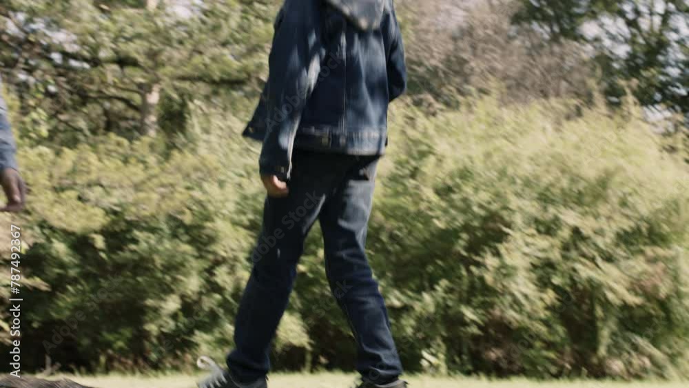Boy walks on a log outside and greets his dad Boy walks on a log outside and greets his dad