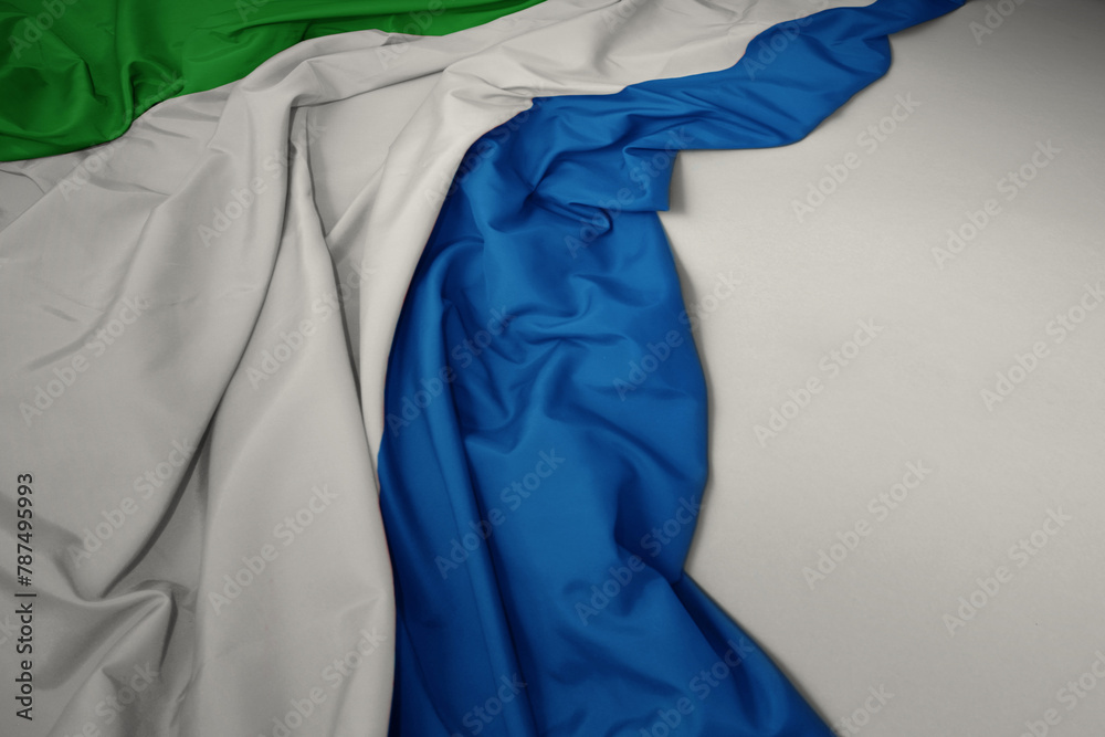 waving national flag of sierra leone on a gray background.
