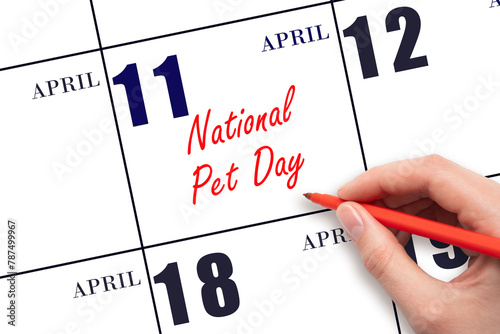 April 11. Hand writing text National Pet Day on calendar date. Save the date.