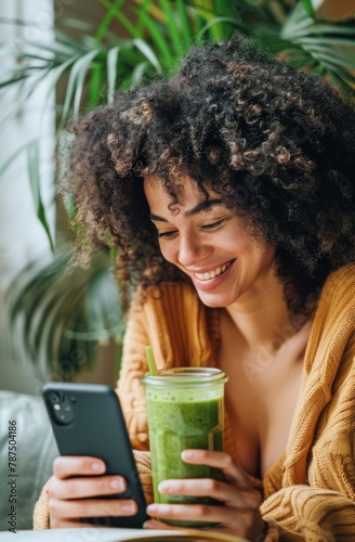 Woman Holding Drink and Looking at Cell Phone