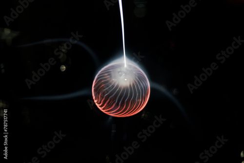 Electricity plasma sphere ball isolated on a black background with ray going out of it