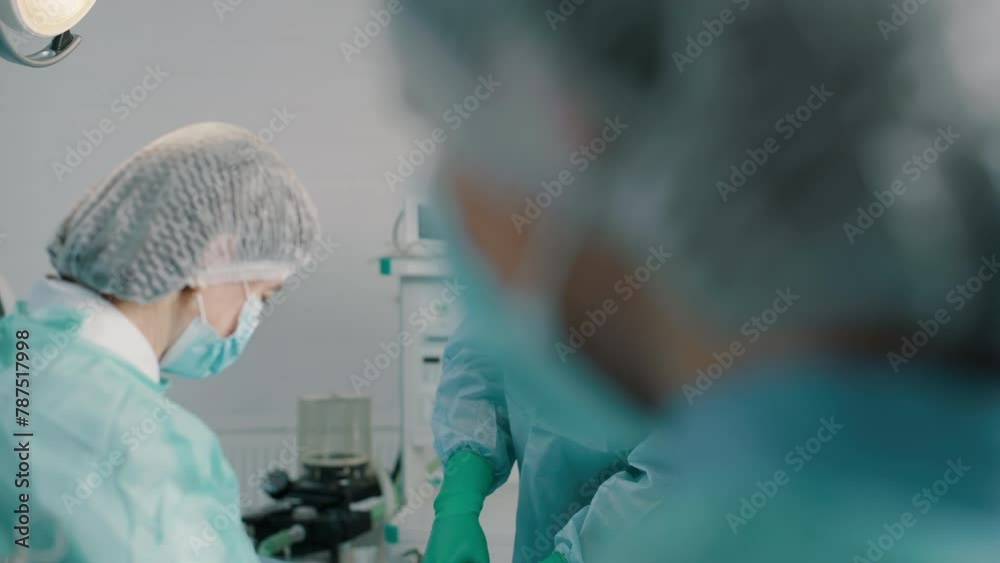 Group of mixed-races professional surgeons and nurses in uniform performing heart transplant surgery operation under bright lamps using medical instruments in operating room Group of mixed-races professional surgeons and nurses in uniform performing heart transplant surgery operation under bright lamps using medical instruments in operating room