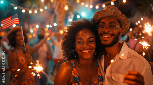A young African American couple celebrates holiday festivity Independence Day in the United States on July 4th with lights in the night and fireworks