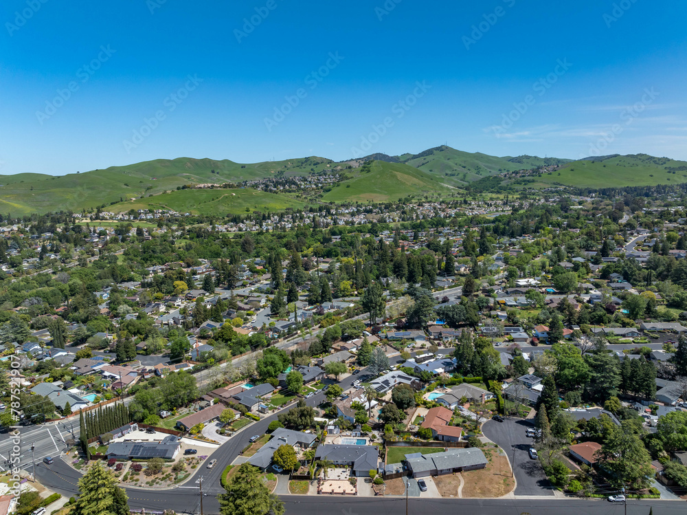 Aerial images over the beautiful landscape hills and communities in Clayton, California with green hills and homes