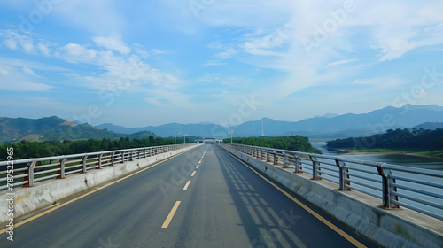 A long road bridge over the river with views of the mountains in the distance. Asphalt highway. © Aleksandra Ermilova