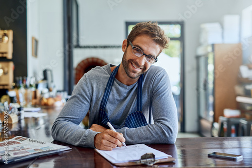 Coffee shop, waiter and portrait of man with clipboard for inventory, review and feedback in store. Small business, documents and person with pen for checklist, planning or price list of stock