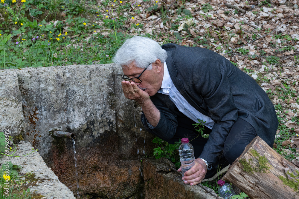 Man filling water by hand from a fountain in nature. Man filling water by hand from a fountain in nature.