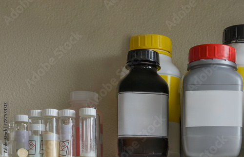 Shelf filled with various chemical bottles. Mockup.