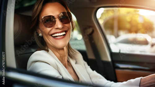elegant elderly lady sits behind the wheel of her car. Elderly businesswoman with a phone in her hand.
