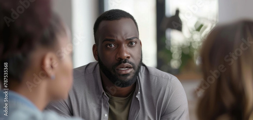 African american man is addressing a diverse group of individuals, engaging in conversation and sharing information