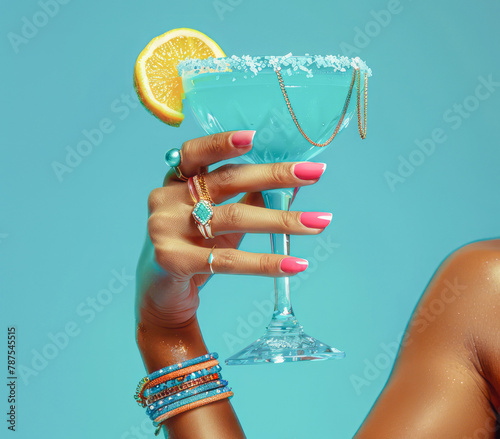 
Hand holding a colorful cocktail with a salted rim, nails matching a blue background, adorned with rings—ideal for luxury drink branding. Concept: Sophisticated presentation.