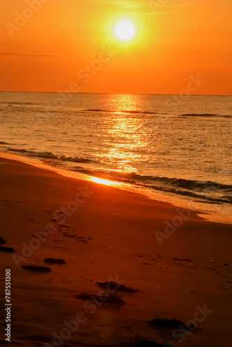 amanecer dorado de verano en playa con huellas en la arena