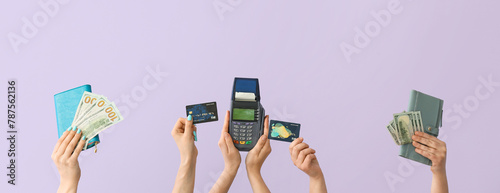 Women with money, wallets, credit cards and payment terminal on lilac background