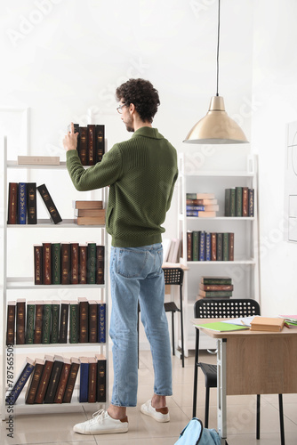 Male student taking book fr...
