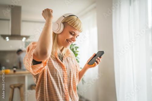Young woman with headphones listen music on mobile phone happy photo
