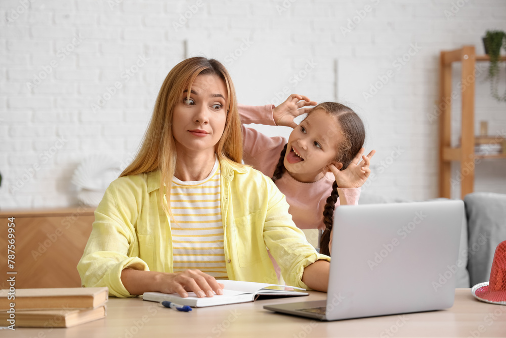Working young woman stressed of her naughty little daughter at home Working young woman stressed of her naughty little daughter at home