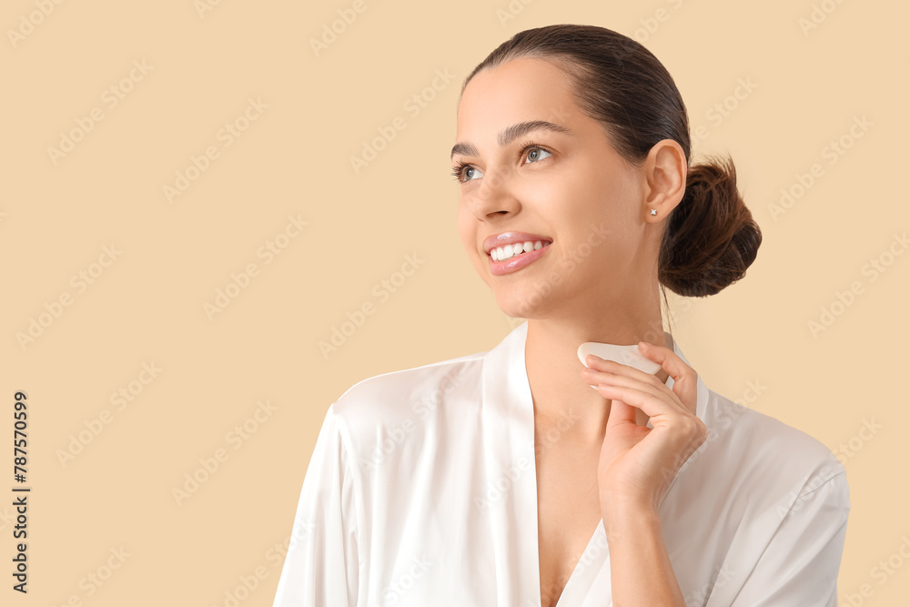 Beautiful young woman massaging her neck with guasha on beige background, closeup Beautiful young woman massaging her neck with guasha on beige background, closeup