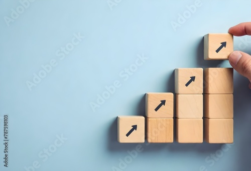 Wooden blocks with arrows pointing upwards arranged in a staircase formation against a white background
