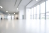 Blurred interior of a modern building with large windows and ceiling lights
