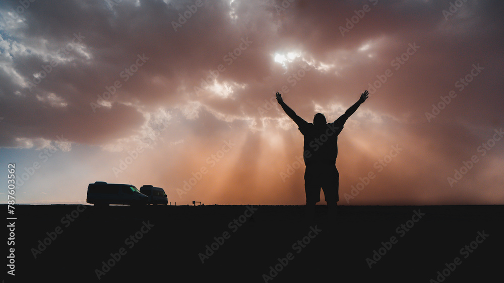 silhouette of person with arms raised