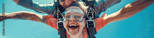 A person with a mobility impairment smiling while skydiving with the assistance of an experienced instructor photo