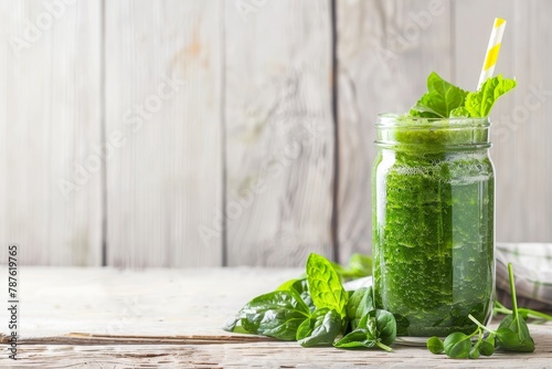 Spinach smoothie in glass jar on white wood with space for text