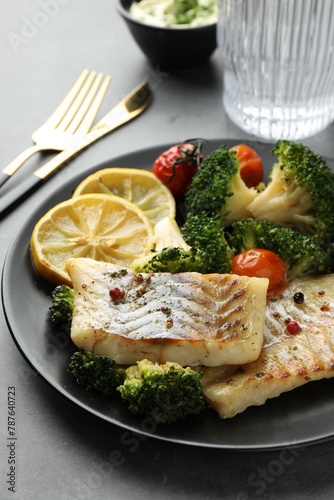 Tasty cod cooked with vegetables served on grey table, closeup