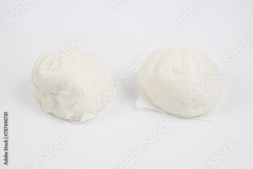 Steamed buns with minced pork on bamboo cutting board. Chinese food dim sum style on white background. Breakfast Asian food.	

