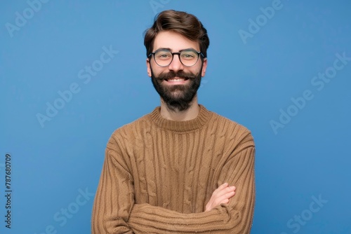 Young handsome man with beard wearing casual sweater and glasses over blue background happy face smiling with crossed arms looking at the camera. Positive person - generative ai