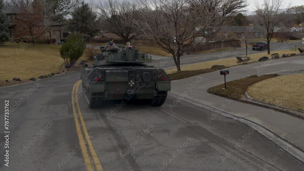 Cinematic drone shot of ancient tank traveling down neighborhood road Cinematic drone shot of ancient tank traveling down neighborhood road