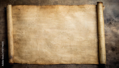 An aged papyrus manuscript, unrolled, displaying a textured surface with dark spots on a wooden background.